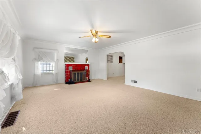 an empty room with windows and ceiling fan