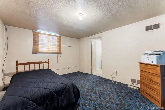 a bedroom with a bed and dresser with mirror