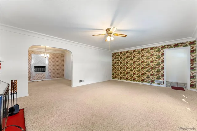 en empty room with windows and ceiling fan