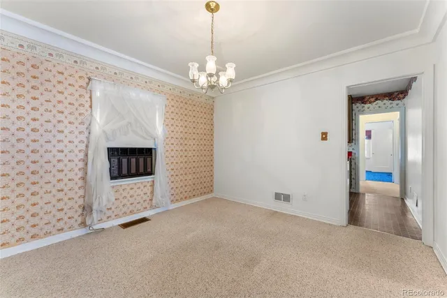 a view of a livingroom with a fireplace a chandelier and windows