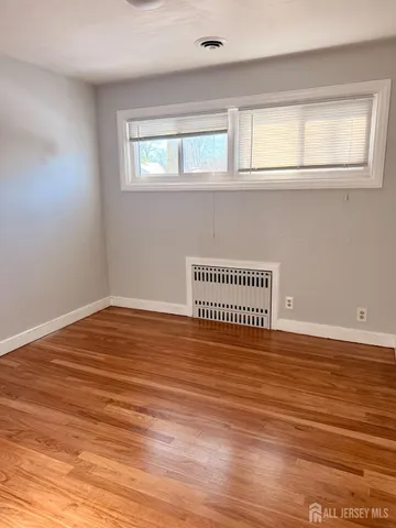 a view of a room with wooden floor and window