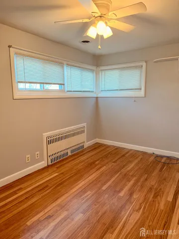 a view of a room with wooden floor and fan