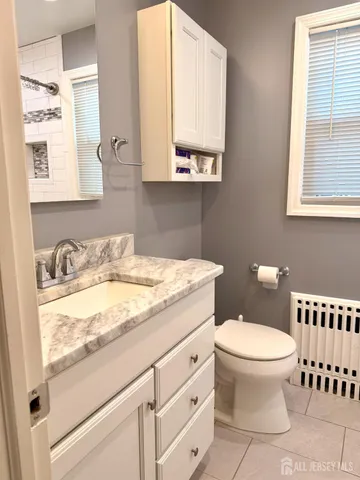 a bathroom with a granite countertop toilet sink and mirror