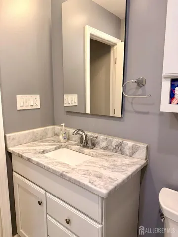 a bathroom with a granite countertop sink and a mirror