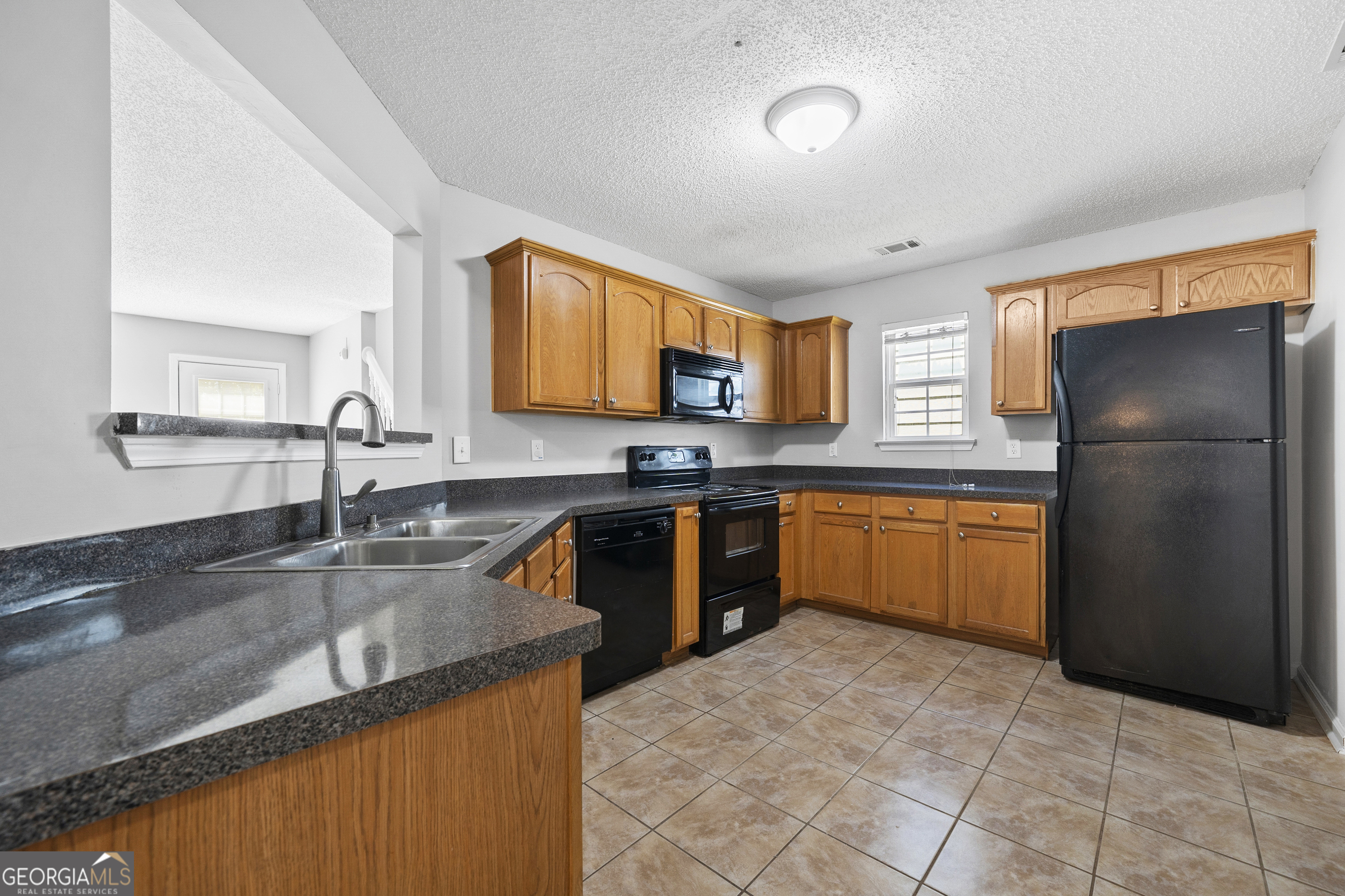 1883 Simmons Lane Hampton, GA 30228 - Photo 4 of 28 a kitchen with stainless steel appliances granite countertop a sink stove and refrigerator