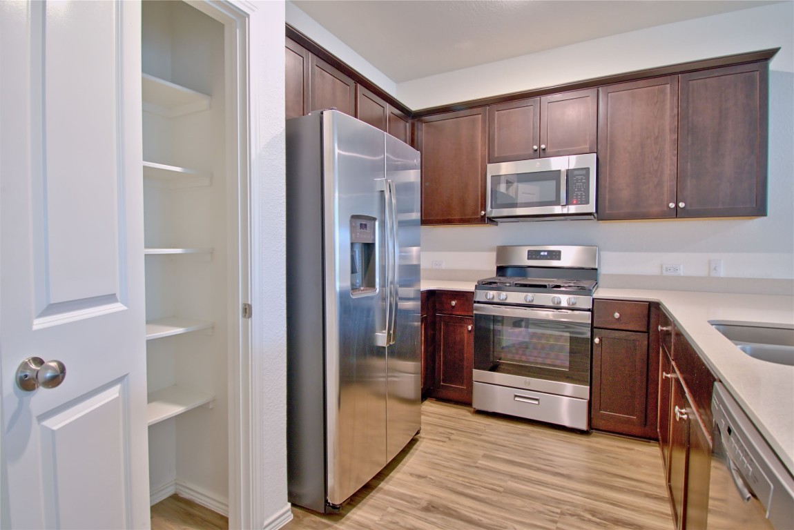 2233 Forgetmenot Lane Pflugerville, TX 78660 - Photo 18 of 28 a kitchen with stainless steel appliances and wooden cabinets