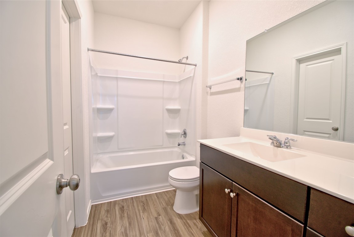 2233 Forgetmenot Lane Pflugerville, TX 78660 - Photo 23 of 28 a bathroom with a sink a toilet a mirror and shower