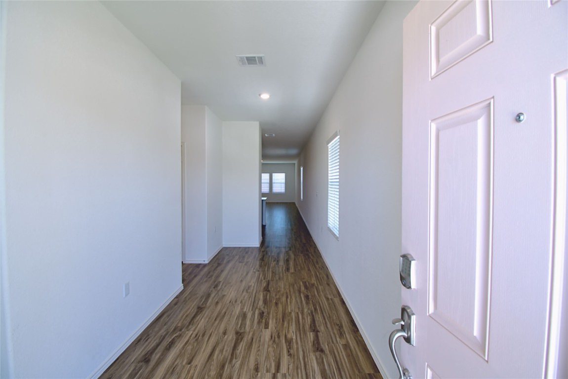 2233 Forgetmenot Lane Pflugerville, TX 78660 - Photo 4 of 28 a view of a hallway with wooden floor and staircase