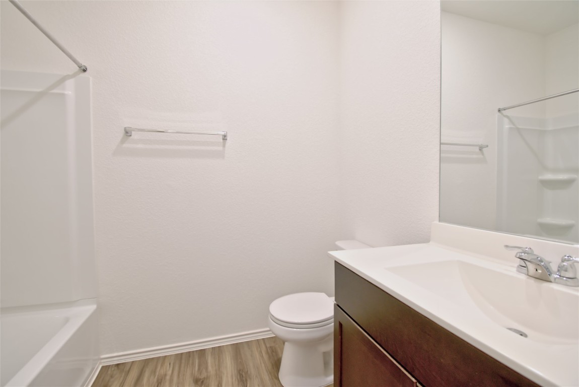 2233 Forgetmenot Lane Pflugerville, TX 78660 - Photo 8 of 28 a bathroom with a granite countertop toilet and a sink