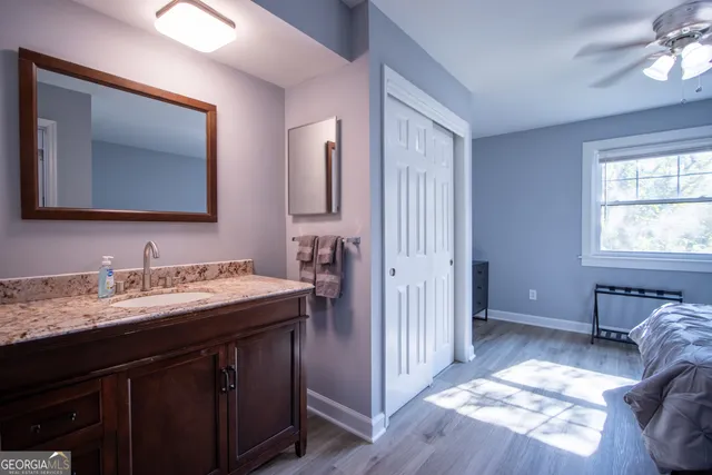 a en suite bathroom with a granite countertop sink and a mirror