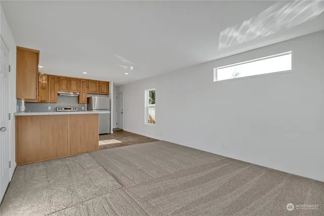 a view of a kitchen with kitchen island a sink wooden floor and a refrigerator