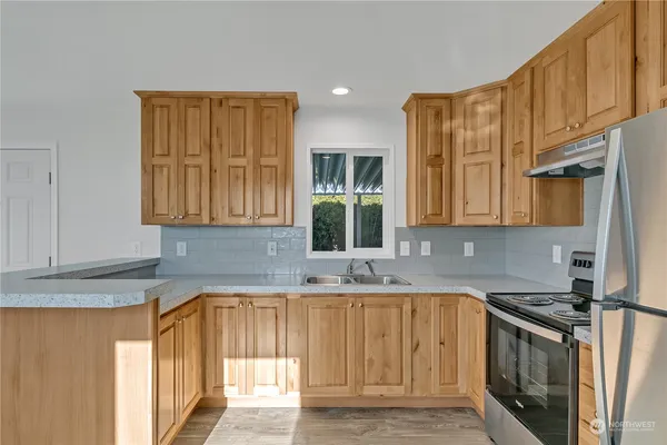 a kitchen with stainless steel appliances granite countertop a sink stove and cabinets