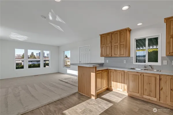 a open kitchen with cabinets a window and sink