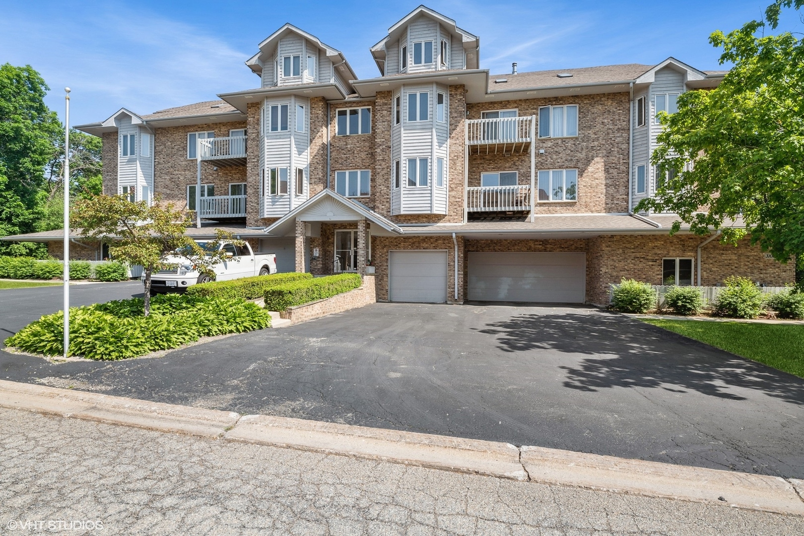 a front view of a house with a yard and potted plants