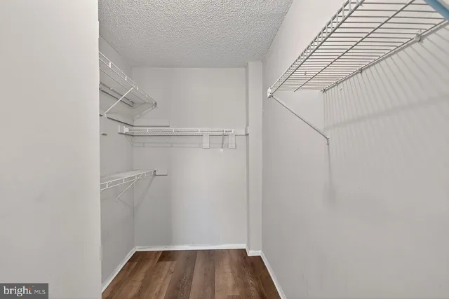 a view of walk in closet with empty racks