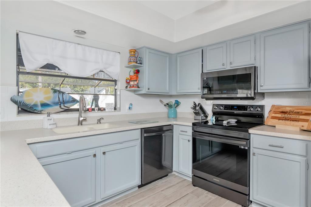 2604 Goldcrest Place Valrico, FL 33596 - Photo 14 of 72 a kitchen with white cabinets and appliances