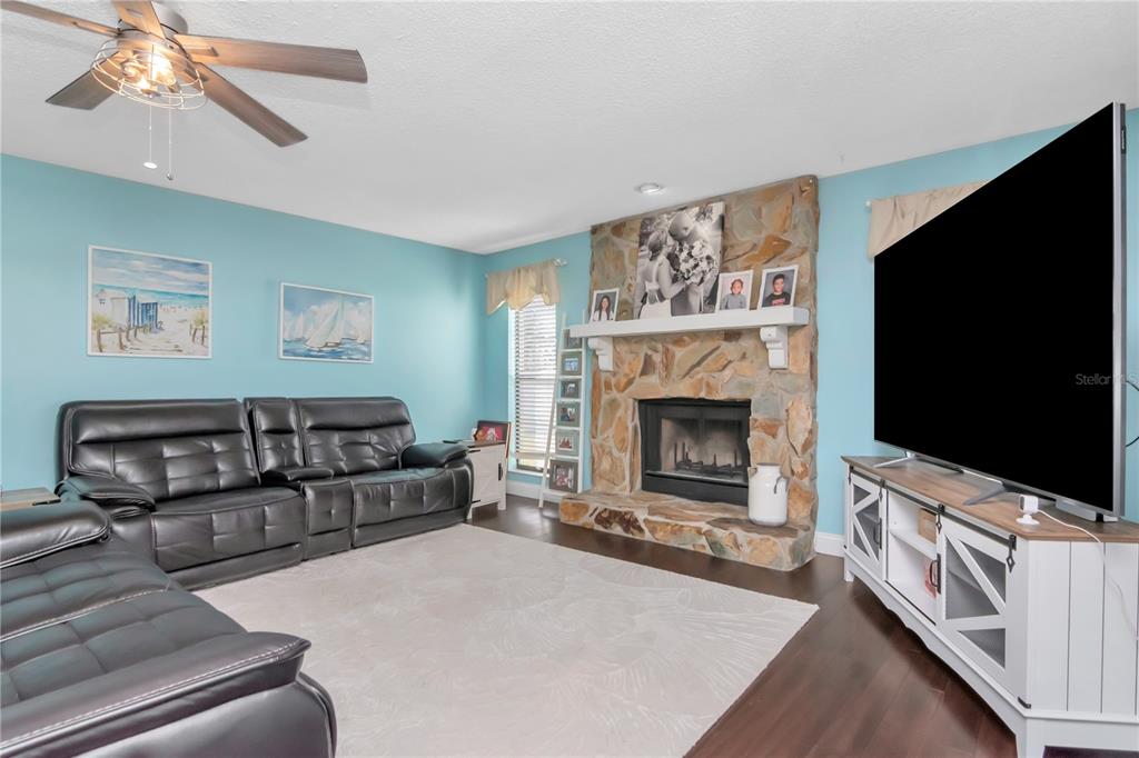 2604 Goldcrest Place Valrico, FL 33596 - Photo 19 of 72 a living room with furniture a flat screen tv and a fireplace