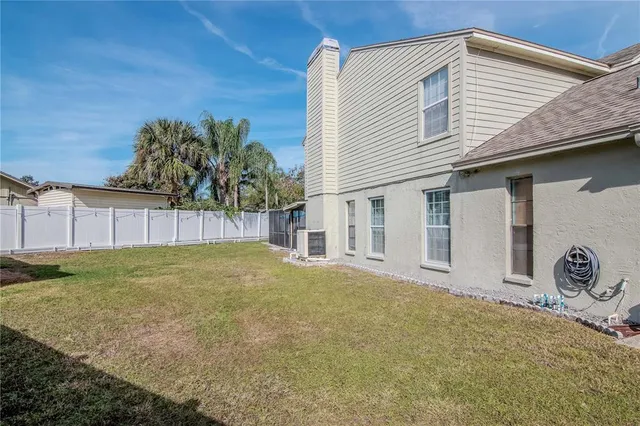 an aerial view of a residential houses with outdoor space and trees