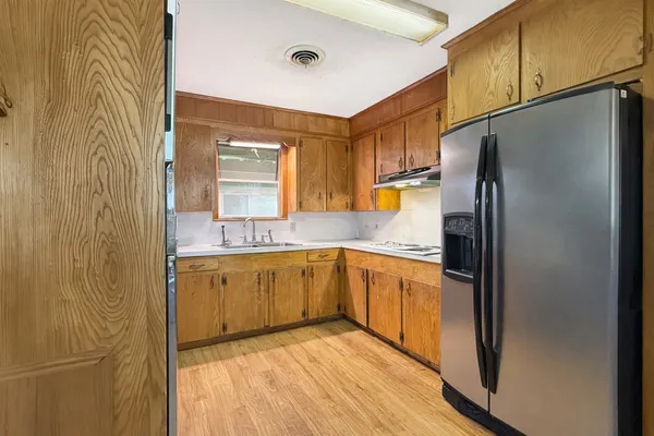 a kitchen with stainless steel appliances granite countertop a refrigerator and a sink