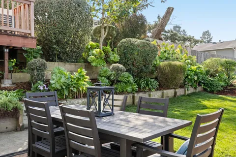 a backyard of a house with table and chairs