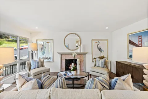 a living room with furniture a fireplace and a large window