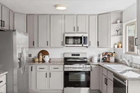 a kitchen with white cabinets and stainless steel appliances
