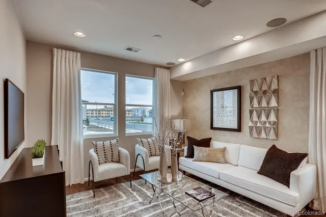 a living room with stainless steel appliances kitchen island granite countertop furniture a rug kitchen view and a window