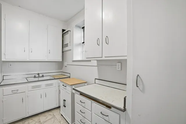 a kitchen with white cabinets appliances and sink