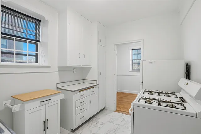 a kitchen with white cabinets and white appliances