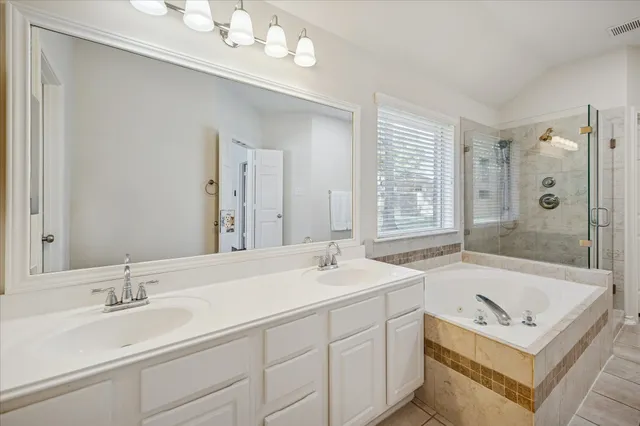 a bathroom with a sink a toilet a mirror and shower