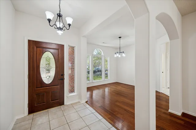 a view of a hallway with entryway wooden floor and front door
