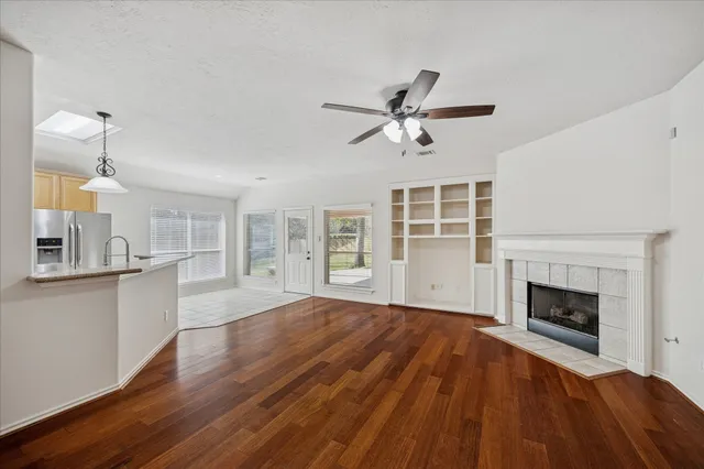 a view of empty room with fireplace and wooden floor