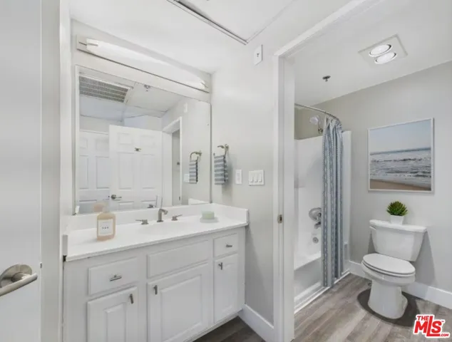 a spacious bathroom with a toilet a sink a mirror a shower and vanity