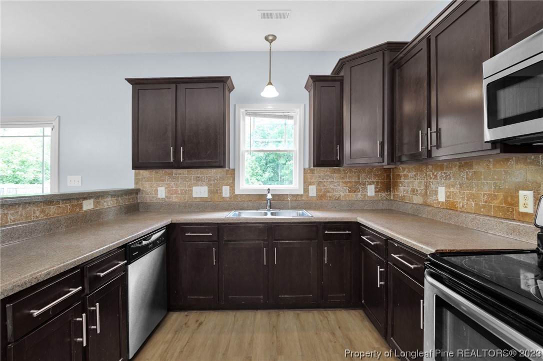 159 Boswell Street Raeford, NC 28376 - Photo 12 of 34 a kitchen with stainless steel appliances a sink stove and cabinets