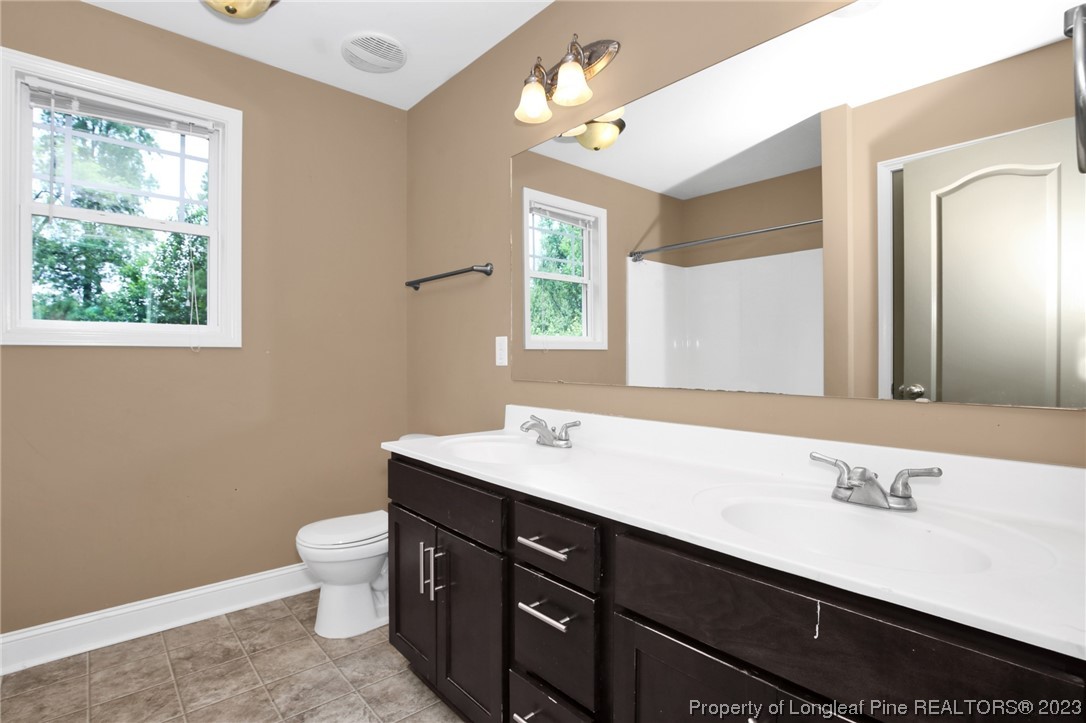 159 Boswell Street Raeford, NC 28376 - Photo 28 of 34 a bathroom with a sink a large mirror and a toilet
