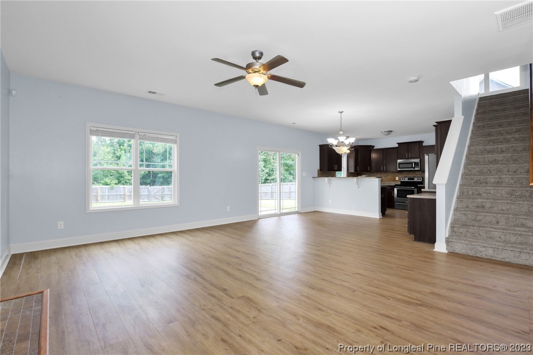 159 Boswell Street Raeford, NC 28376 - Photo 9 of 34 a view of a livingroom with furniture wooden floor ceiling fan and windows