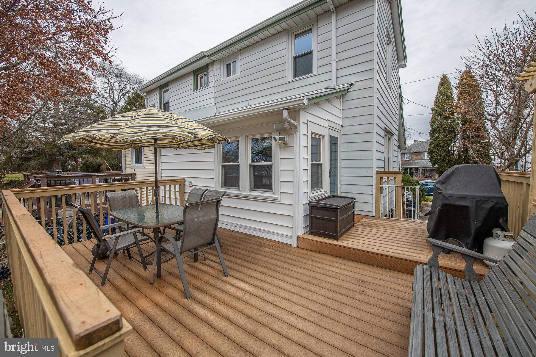 560 Wales Road Havertown, PA 19083 - Photo 58 of 69 a view of a roof deck with table and chairs under an umbrella with wooden floor