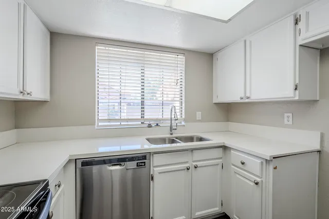 a kitchen with a sink cabinets appliances and a window