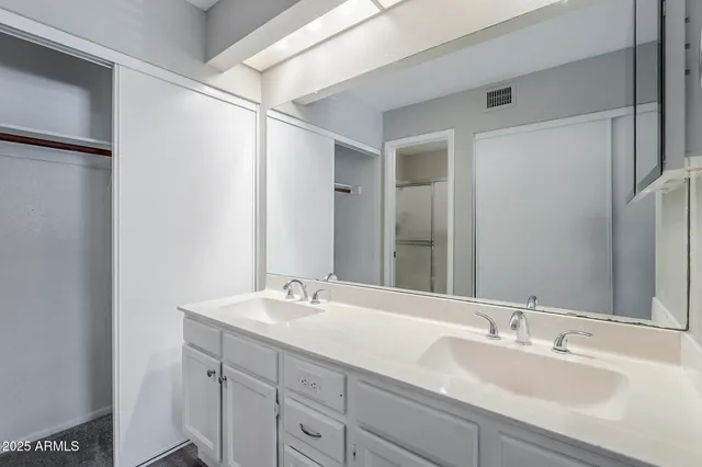 a bathroom with a double vanity sink and a mirror