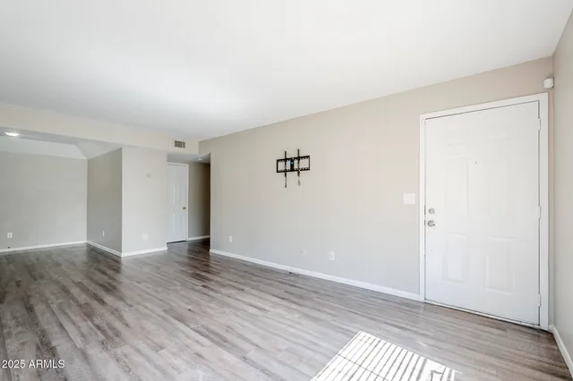 a view of an empty room with wooden floor