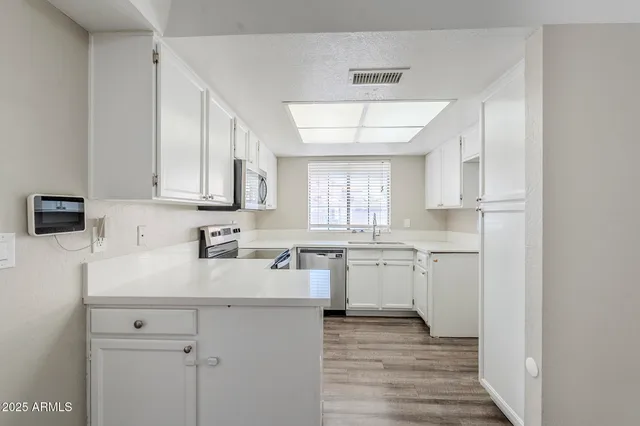 a kitchen with a sink cabinets and wooden floor