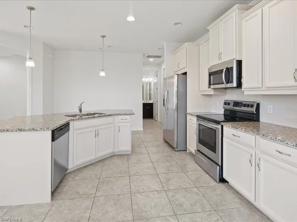 a kitchen with white cabinets stainless steel appliances and sink