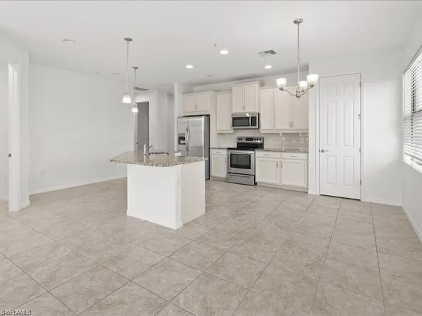 a large kitchen with cabinets and stainless steel appliances