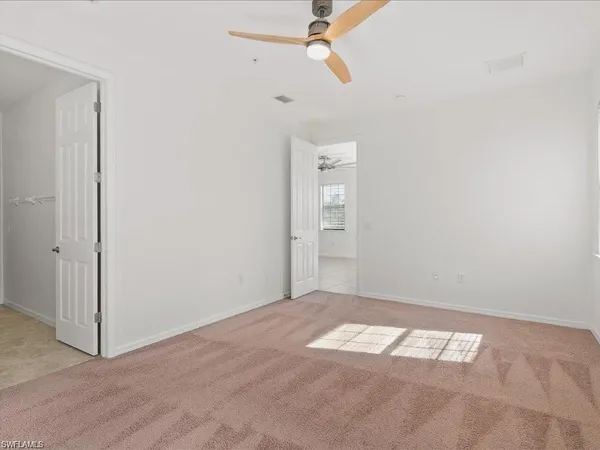 an empty room with a window and a fan