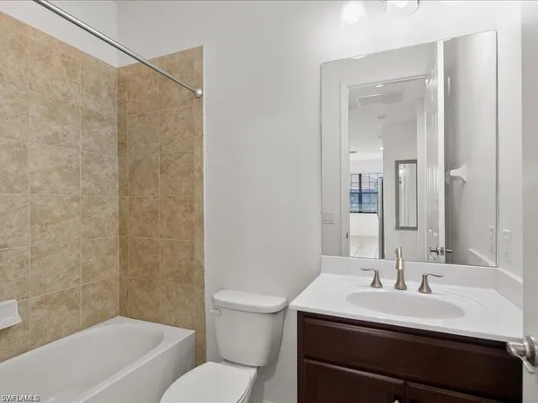 a bathroom with a sink toilet vanity and tub