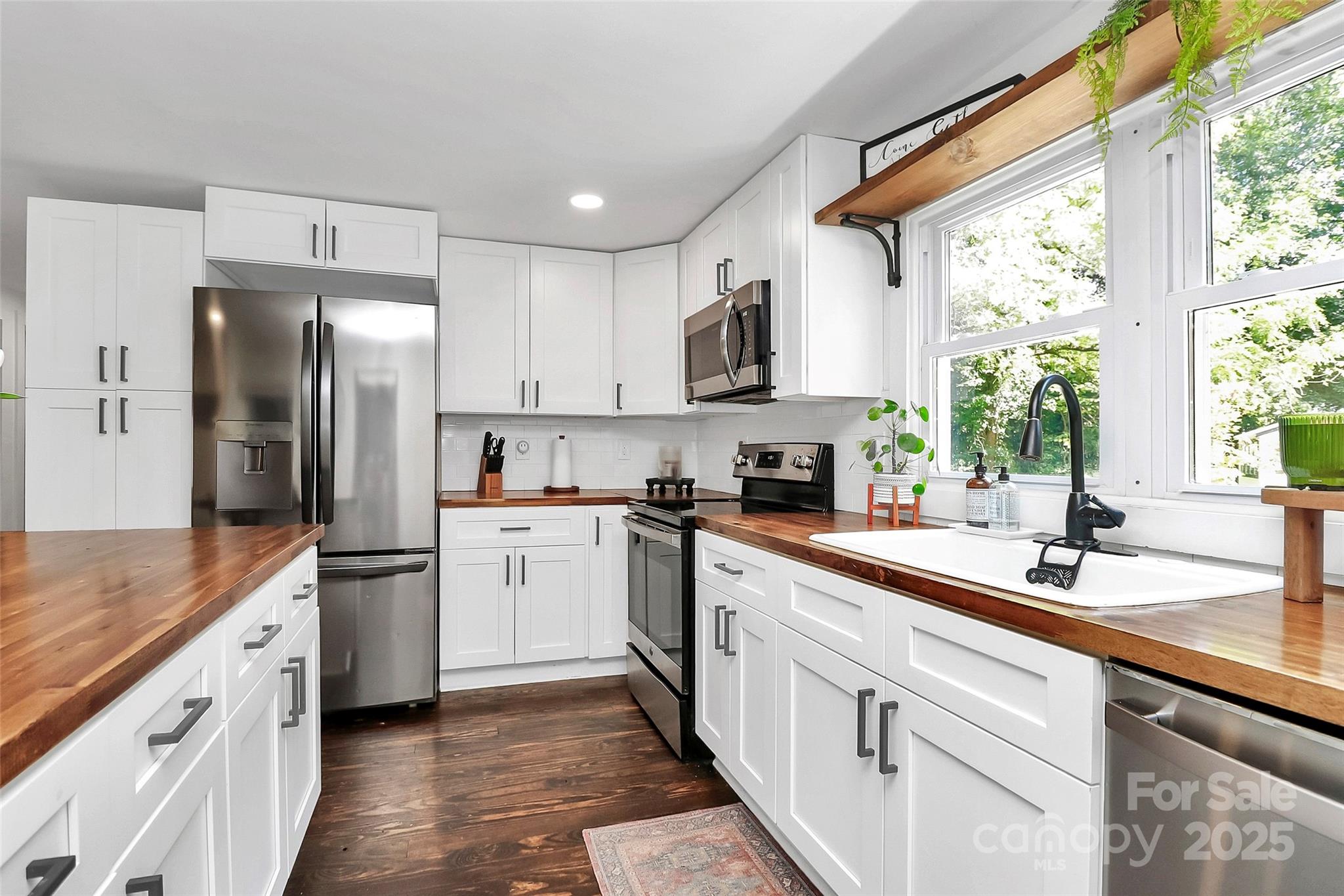 205 Mason Street Belmont, NC 28012 - Photo 5 of 27 a kitchen with white cabinets and white appliances
