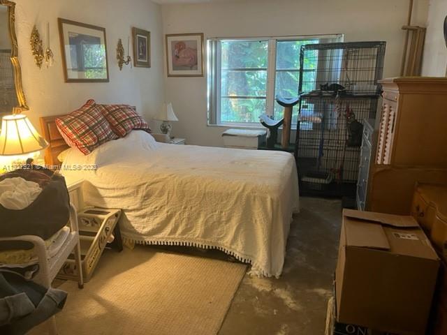 14036 Southwest 90th Avenue, Unit 103AA Miami, FL 33176 - Photo 11 of 13 a bedroom with a bed and dresser with mirror