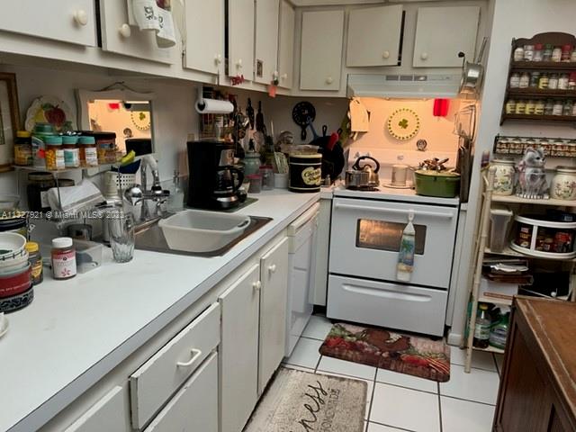 14036 Southwest 90th Avenue, Unit 103AA Miami, FL 33176 - Photo 10 of 13 a kitchen with a refrigerator and cabinets