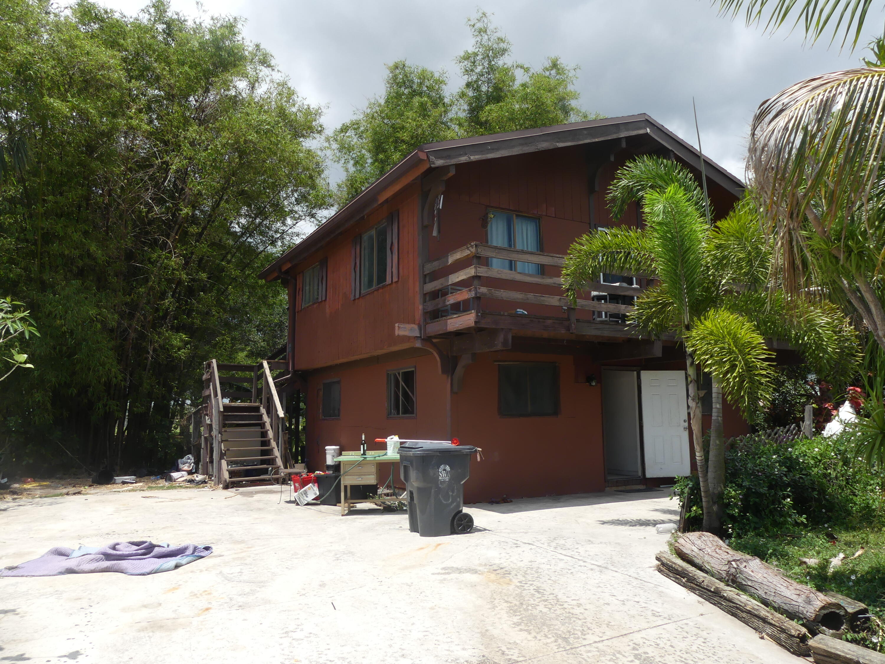 6633 Rigger Road Lake Worth, FL 33462 - Photo 20 of 28 a backyard of a house with table and chairs under an umbrella