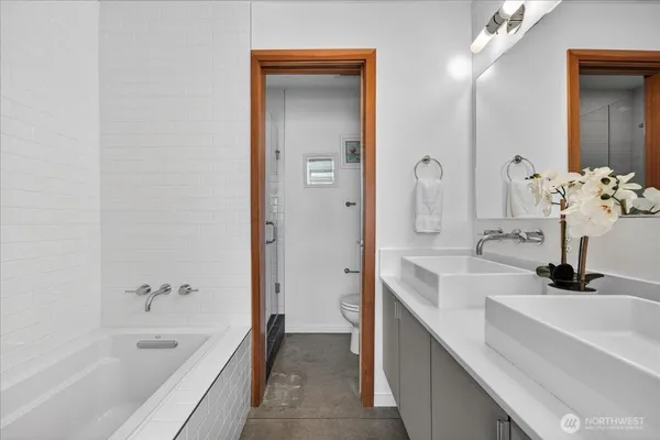 a bathroom with a tub sink and mirror